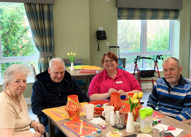 Residents enjoying a colourful arts and crafts activity with a team member