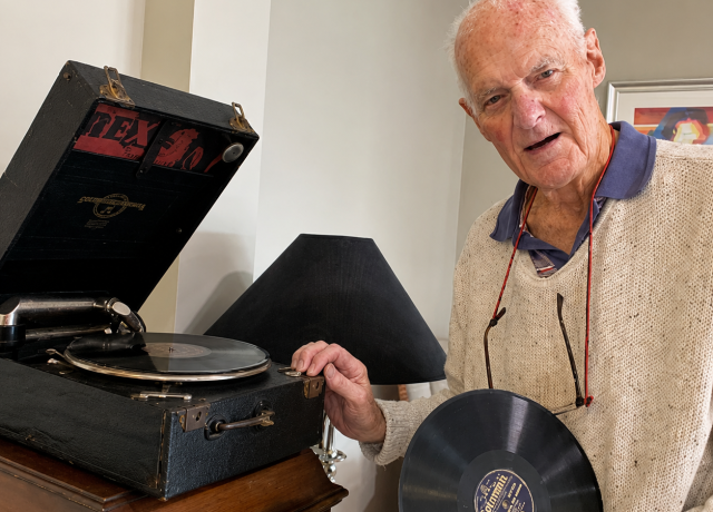 Resident Derek enjoying a reminiscence activity with a vintage record player and vinyl record